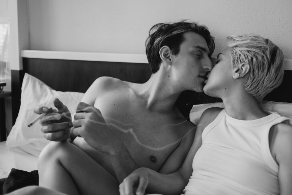 Intimate Couple Smoking and smooching in bed.